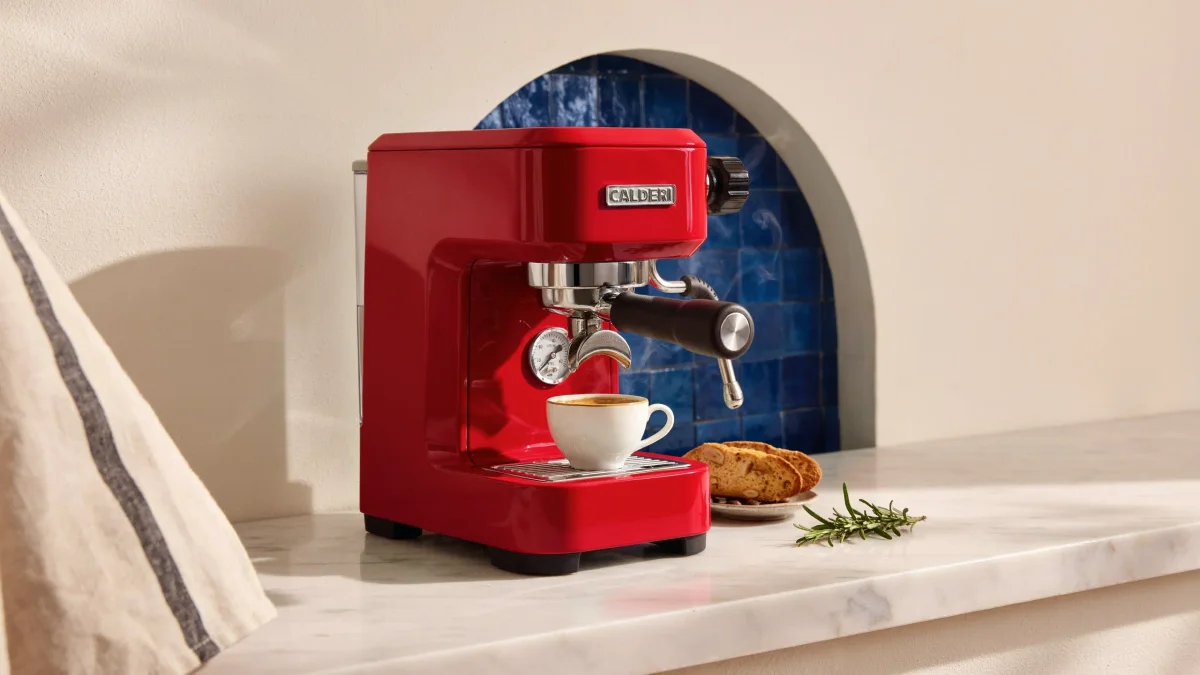 Cherry-red espresso machine with almond biscotti beside the cup
